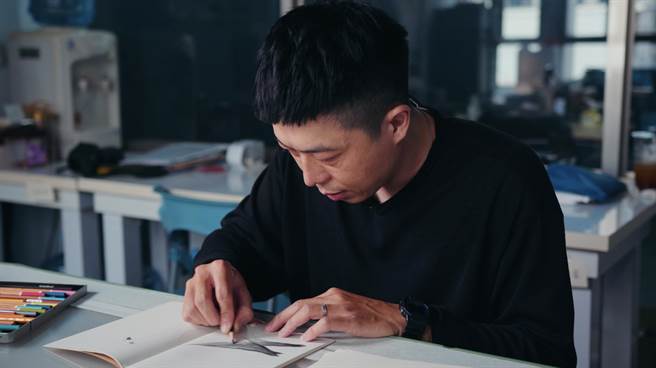 攝影師李立中於工作室手繪鴿子。（主辦單位提供）