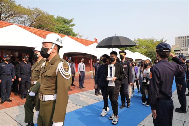 台南殉职巡警曹瑞杰今日入祀忠烈祠，由家属捧着牌位步入忠烈祠。(台南市政府提供／曹婷婷台南传真)