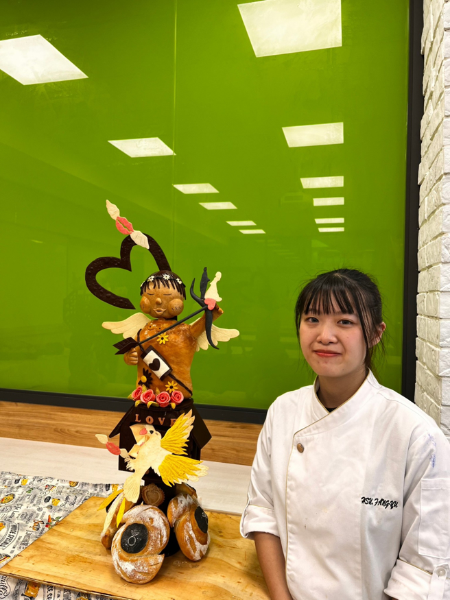 艺术麵包设计第二名许芳瑜同学与参赛作品「爱神之箭」合影。(照片/中臺科大提供)
