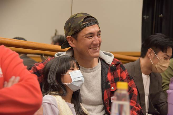 阿布（中）受邀参与整排，大女儿薰薰（左ㄧ）依偎在爸爸身旁认真看戏。（梦田影像提供）