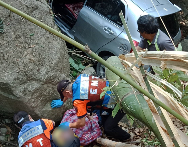 一辆轿车29日行经台南及嘉义交界山区的产业道路时，因不明原因衝破护栏坠落溪谷，驾驶及1名乘客受困车内被消防队救出。（图／翻摄照片）