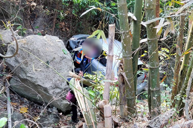 一辆轿车29日行经台南及嘉义交界山区的产业道路时，因不明原因衝破护栏坠落溪谷，驾驶及1名乘客受困车内被消防队救出。（图／翻摄照片）