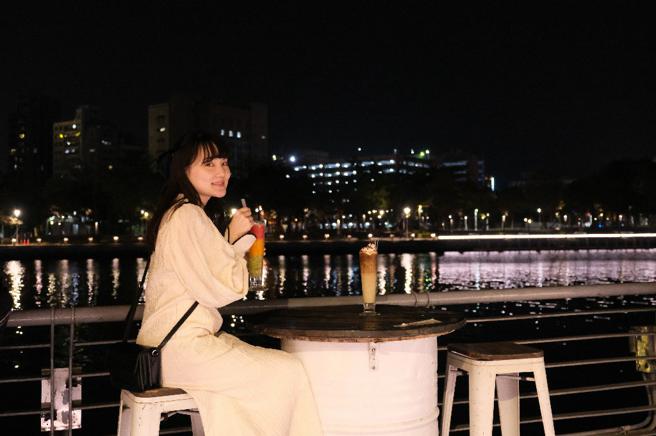日籍网红Sato酱（佐藤あさえ）在爱河畔喝饮品谈心享受夜港都(高雄市观光局提供)