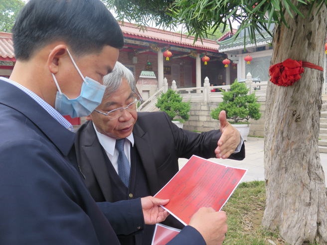 作者陈益源与三平寺卢文深主任讨论田野文献。（作者提供）