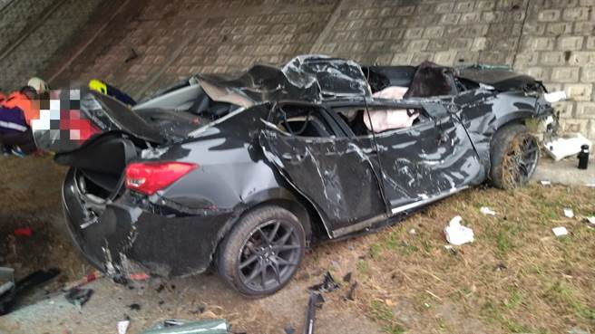 自小客疑似高速接連撞擊橋墩、紐澤西護欄後衝下邊坡，隨後又撞到交流道的大柱子才卡在坡坎前。（嘉義縣消防局提供∕呂妍庭嘉義傳真）