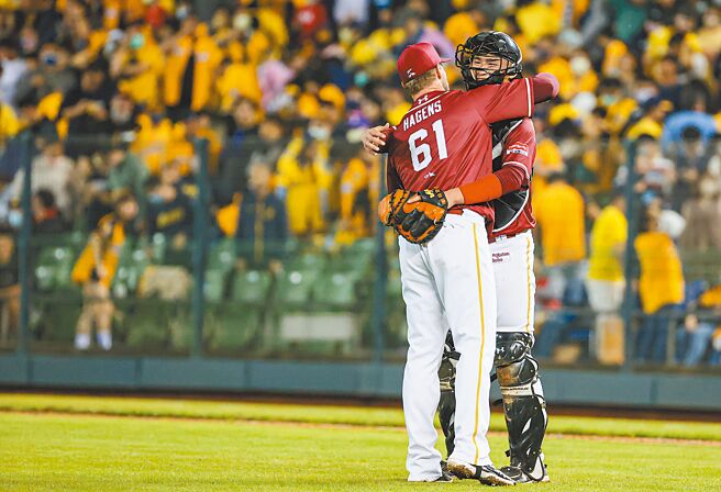 乐天桃猿18岁捕手宋嘉翔（右）创中职开幕战最年轻先发球员纪录，且对中信兄弟蹲满全场，最后与拿下救援成功的洋投豪劲拥抱庆祝胜利。（中央社）