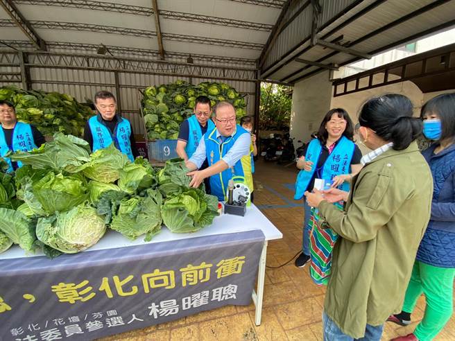 彰化市牙医师杨曜聪（中）买下一千五百颗高丽菜后，免费分送给民眾。（孙英哲摄