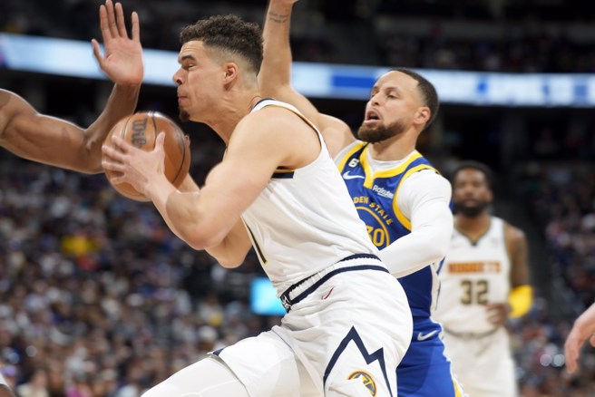 柯瑞(右)全力阻挡麦克波特的持球切入。(美联社)