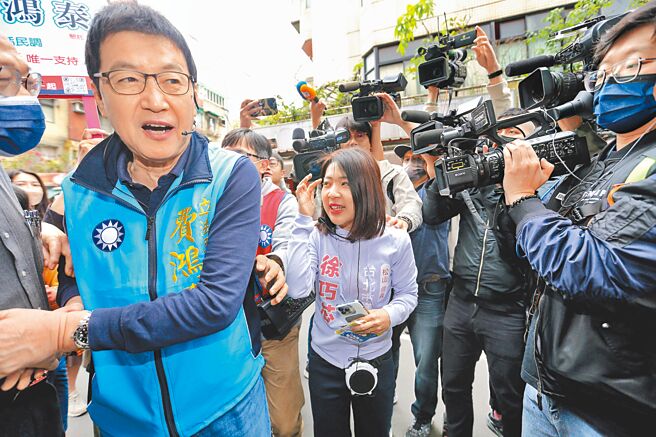 国民党台北市信义、南松山区立委初选热战，市议员徐巧芯（中）与立委费鸿泰（左）激烈竞争，双方阵营2日在中崙市场狭路相逢，徐巧芯上前邀费鸿泰辩论，费没有正面回应，仅说团结对外，不要打内战，转身继续拜票。（黄世麒摄）