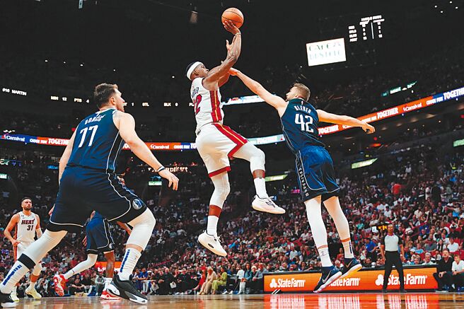 吉米巴特勒（中）在空中躲过对方封阻出手投篮。（路透）