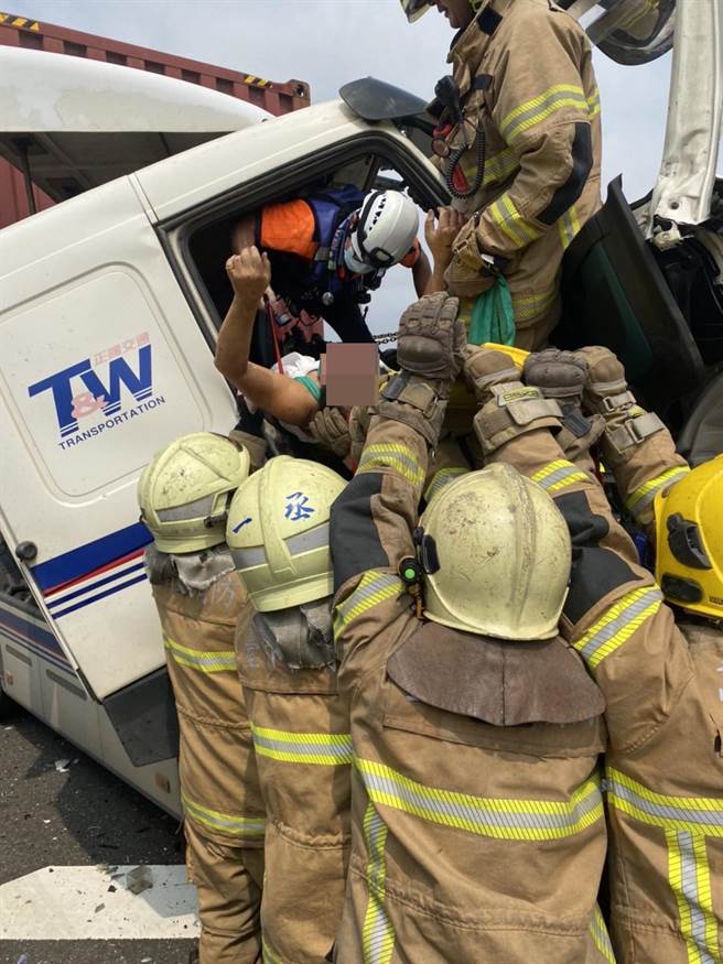 消防人員齊力將貨車上的貨櫃車駕駛救出。（讀者提供／張毓翎台南傳真）