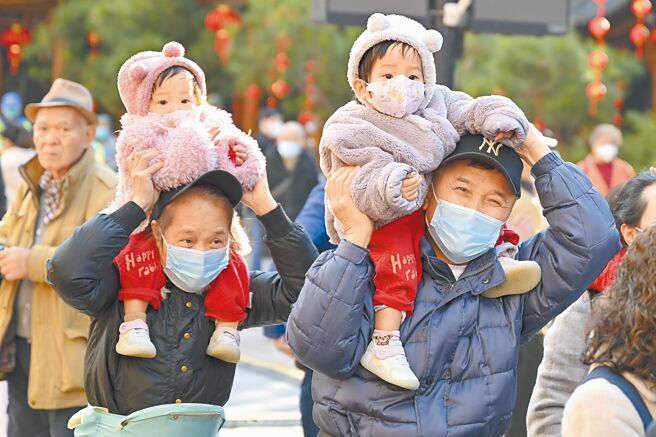 廣州市民帶著兒童逛西湖花市，迎接新春。（中新社）