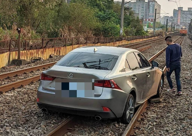 銀色的小客車與鐵軌平行，卡在平交道上無法動彈。（民眾提供／陳夢茹桃園傳真）