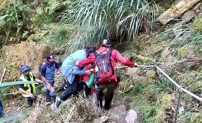 彭姓女子参加神阿纵走脚扭伤，搜救队员轮流将她背下山送医。（南投县消防局提供／杨静茹南投传真）