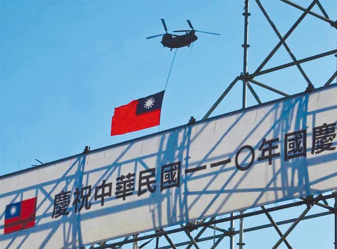 刘世忠将国旗用作垫桌布的行为引发批评。图为110年国庆，国军CH-47悬吊国旗通过总统府上空。（示意图，中时资料照）