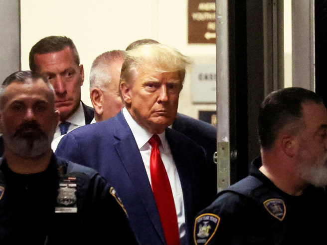 各大美媒4日转播川普出庭应讯，不少网友被曼哈顿法庭一名高挑金髮女警电到。图为川普抵达曼哈顿刑事法院。（图／路透社）