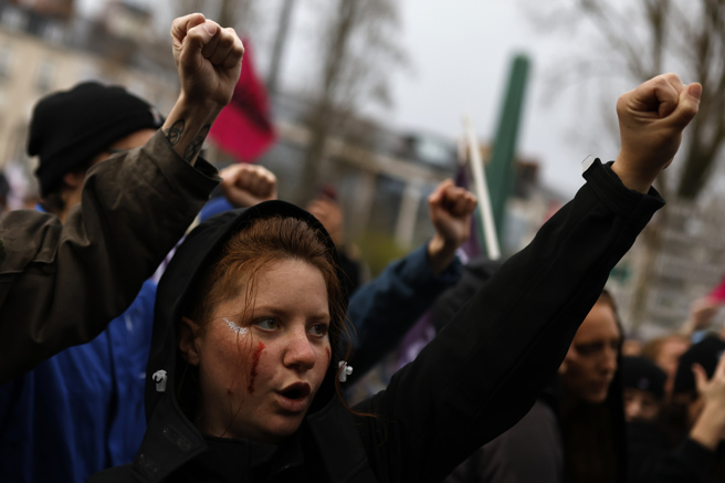 2023年3月30日，法国示威者在政府大楼外举起拳头抗议警察的暴力行为。（美联社）