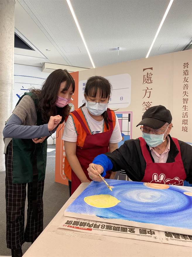 当天活动，现场「金色博士Dr. Golden音乐生活创意中心」讲师（左），与亚大护理系学生，协助长辈画出心中色彩。（亚洲大学提供／张妍溱台中传真）