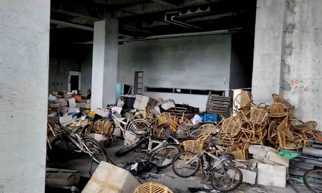 建物一樓挑高大廳內堆滿各式桌椅、建材等廢棄物。（法務部執行署高雄分署提供／袁庭堯高雄傳真）