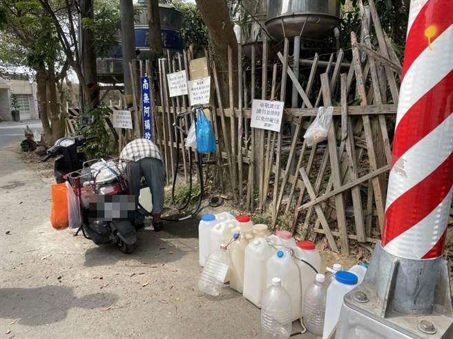 民眾用水桶排隊取水。（洪靖宜攝）