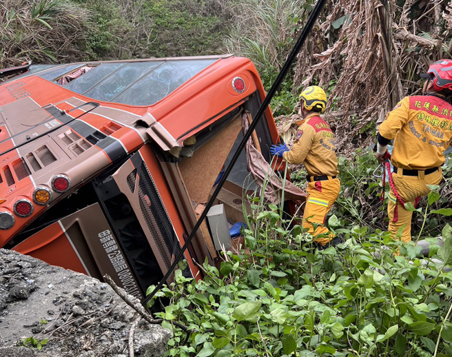 花蓮客運與小客車對撞，客運摔落邊坡1乘客受困，警消正在現場搶救。(王志偉翻攝)