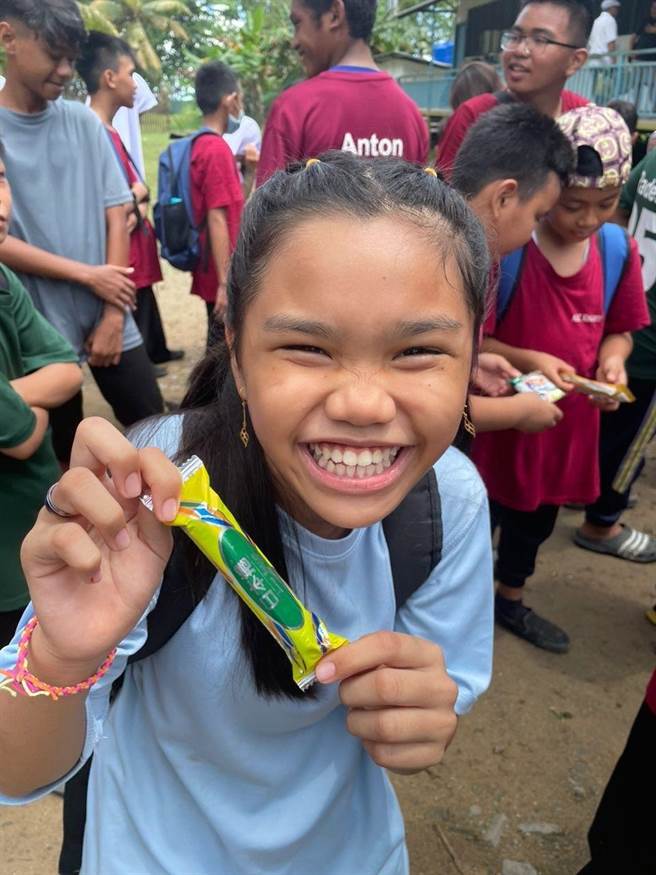 沙巴的小朋友拿到一塊餅干後開心不已。（張雪如提供）