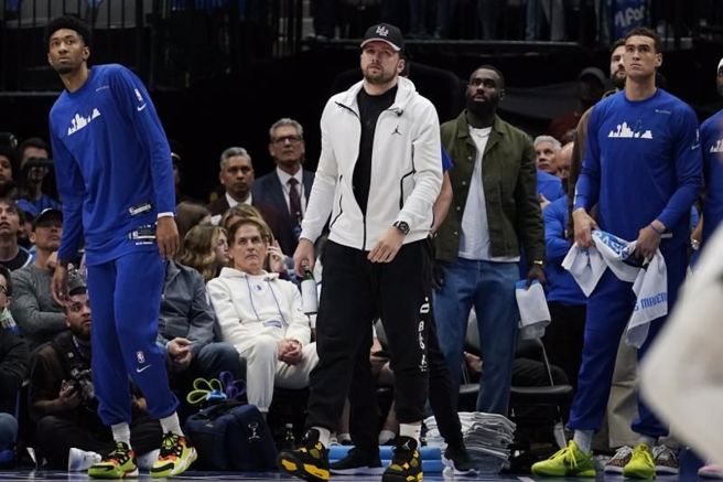 独行侠控卫东契奇(中)在板凳区看比赛。（美联社）