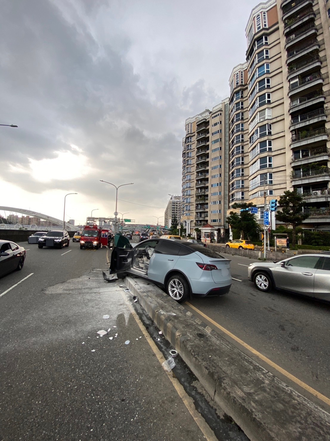 特斯拉轿车直接衝撞分隔岛，车头严重凹陷。（新北消防局提供）