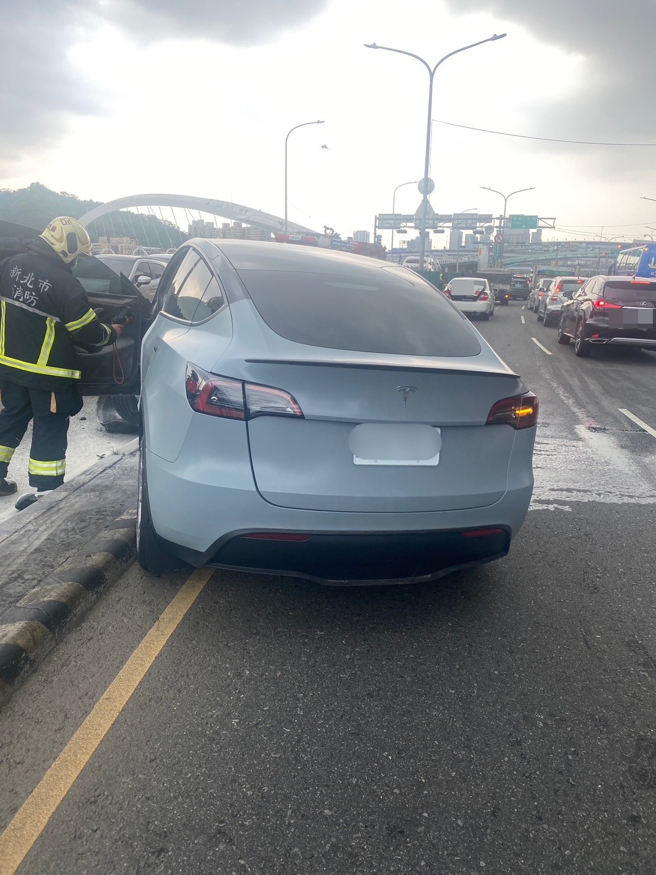 特斯拉轿车直接衝撞分隔岛，车头严重凹陷。（新北消防局提供）