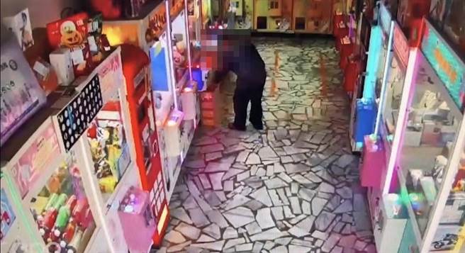 林男趁四下无人，拿走机台旁的饮料。（翻摄照片／高雄洪靖宜传真）