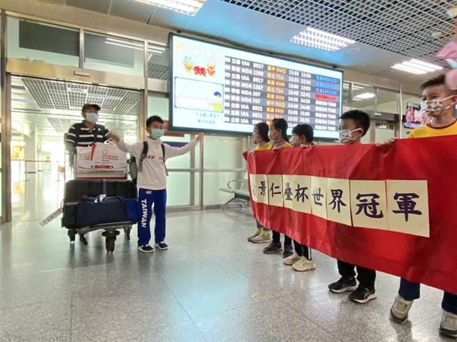 疊杯神童俞景仁(左二)今日中午在爸爸俞紹揚(左一)的陪伴下搭機載譽榮歸，一入境便受到同學熱情的歡迎。(于家麒攝)