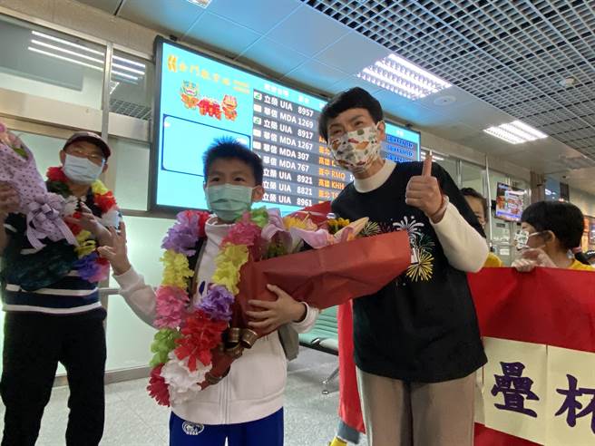 中正國小校長蔡雪芳(右)親自為俞景仁(中)戴上花圈，歡迎他載譽歸來。(于家麒攝)