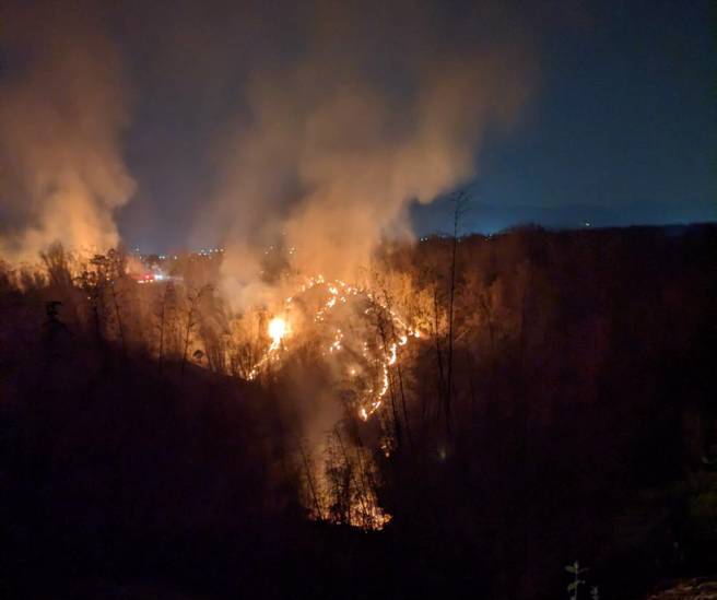 高雄市旗山区沟坪路今天下午3时9分出现杂草火警，消防局出动大批警义消前往抢救，直到晚间火势仍持续延烧扩散。(林雅惠翻摄/义消提供)