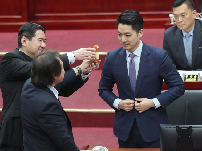 台北市長蔣萬安13日赴台北市議會進行施政報告與質詢及答覆，市議員王世堅（左）在程序發言時批市政螺絲鬆了，表達對蔣萬安的不滿，並送上一副螺絲起子要蔣萬安鎖緊螺絲。（鄭任南攝）