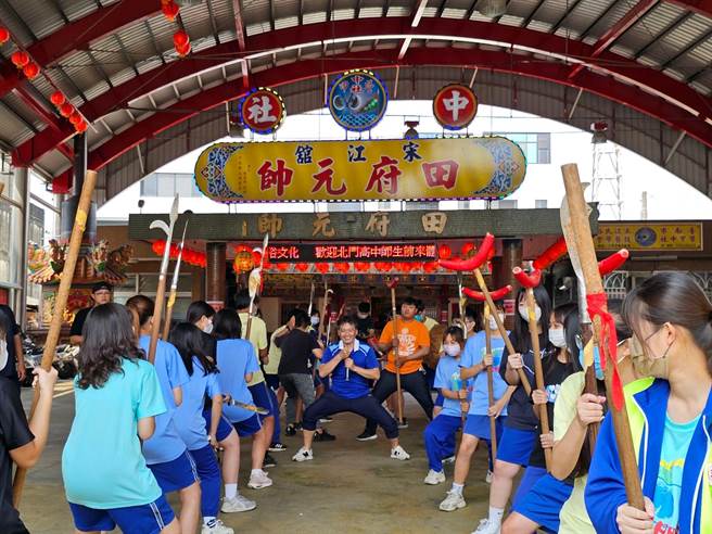 台南北门高中的学生在师傅指导之下，手拿宋江阵兵器，动作一致、齐声吶喊，展现出青年气势。（张毓翎摄）
