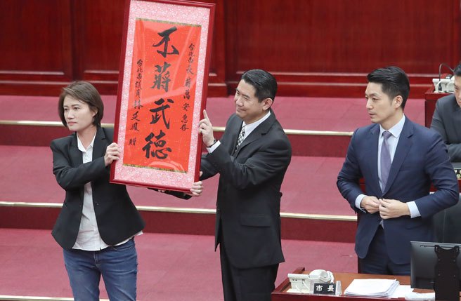 台北市长蒋万安（右）13日赴台北市议会进行施政报告与质询及答覆，市议员林延凤（左）在程序发言时批评蒋万安突袭拜访民进党团，并赠送「不蒋武德」字画，表达对蒋万安的不满。（郑任南摄）