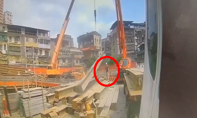 一名工人在指挥钢梁吊挂作业时，H型钢梁当场从空中松脱，一端疑似直接压在工人头上，工人当场消失在地面。（翻摄自记者爆料网）