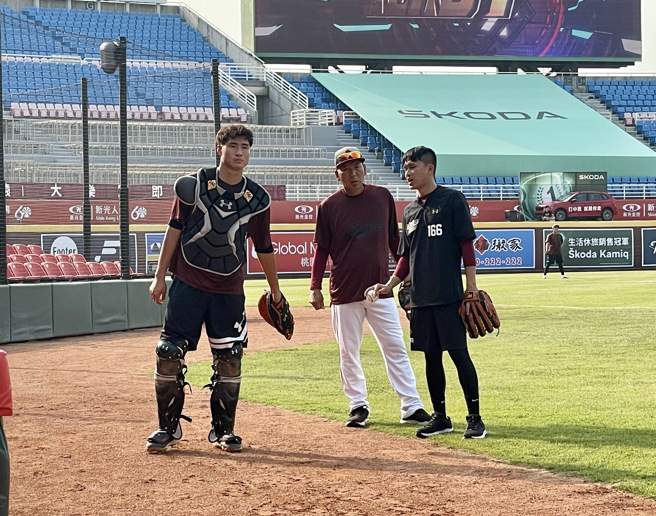 乐天桃猿日籍首席教练古久保健二（中）赛前指导捕手宋嘉翔（左）。（毛琬婷摄）