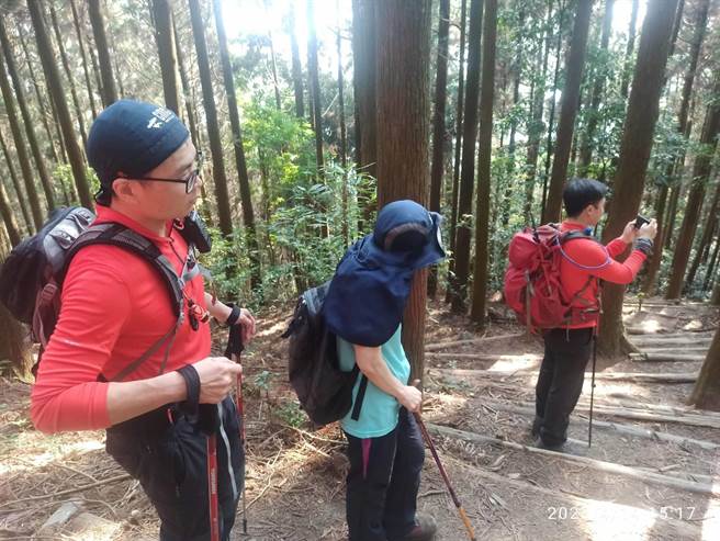 64歲的王姓婦人，獨攀鳶嘴長壽山迷途；搜救人員尋獲後，消防員護送她下山。（台中市消防局提供）