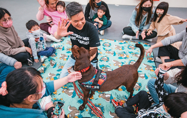 「台湾心辅犬培育团队」技术长锺皓羽示范，如何正确地与狗狗进行第一次接触，建立良好的双向关系。右：团队透过体验活动，让人们认识浪浪、亲身感受牠们的魅力。（摄影／邹保祥）