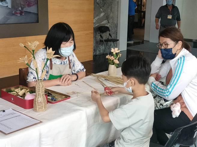 南投草编专家黄宝秀16日下午于国立台湾工艺研究发展中心进行稻草编织技术演艺，吸引前来游玩的亲子驻足。（潘虹恩摄）