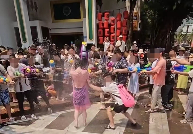 有女子和友人日前去云南参加泼水节活动，竟然发现当场有其他女游客遭撕开雨衣，并且还有一群男子将水枪猛往女子的私密部分狂射。（翻摄自微博）