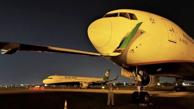 长荣航勤昨日为拖行一架长荣航空A321飞机时，撞破波音777机鼻。（图／读者提供）