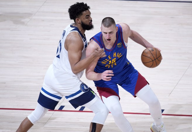 约基奇(右)一边运球，一边跟唐斯身体对抗。(美联社)
