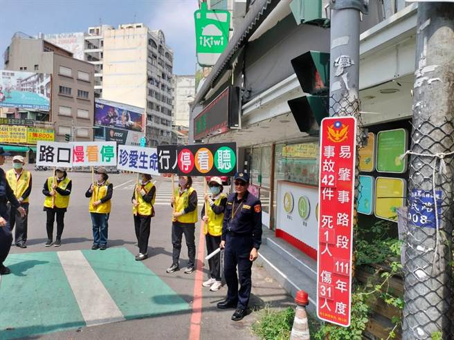 彰化县警局交通队今天在21处易肇事路口设置车祸伤亡数据告示牌，并动员志工举牌宣导。（彰化县警局提供）