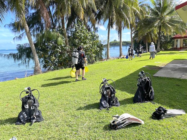 教学、着装完毕后，不必搭船，跟着教练步行到旁边的沙滩慢慢走进海里，不用担心一下就到很深的海水中。（何书青摄）