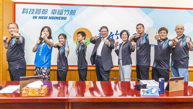 县长杨文科（中）与射箭联队小将一起比出射箭的姿势，期望全中运能再创佳绩。（罗浚滨摄）