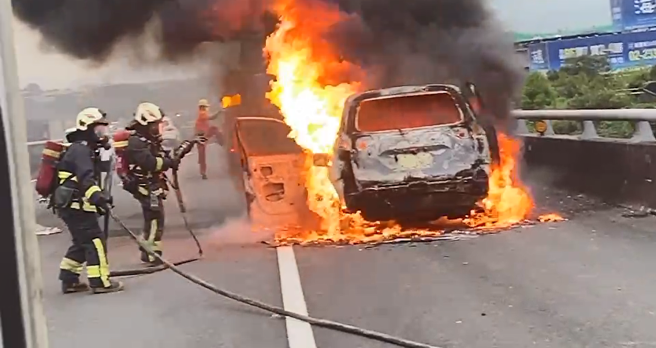 國1北上堤頂高架「火燒車」竄濃煙影響行車，車流回堵中。(警方提供)