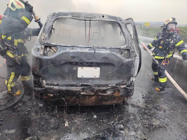 國1北上堤頂高架「火燒車」竄濃煙影響行車，車流回堵中。(警方提供)