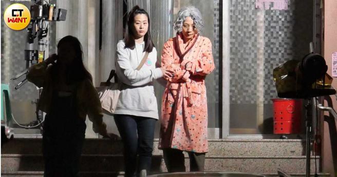 拍片助理搀扶着一位顶着银白卷髮及一身珊瑚绒睡袍的老太太，仔细一看竟然是化了老妆的白灵上场。（图／本刊摄影组）